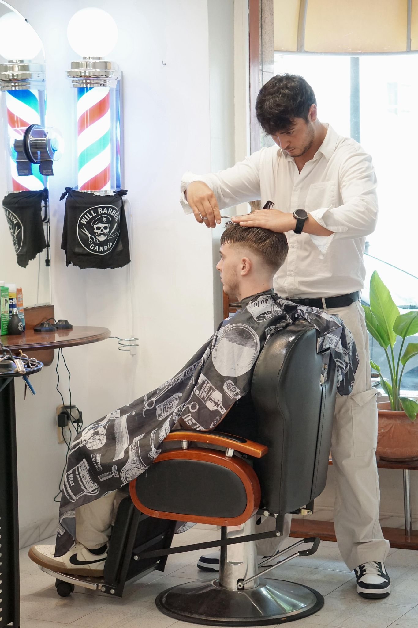 Guillermo realizando un corte de cabello en Peluquería Climent
